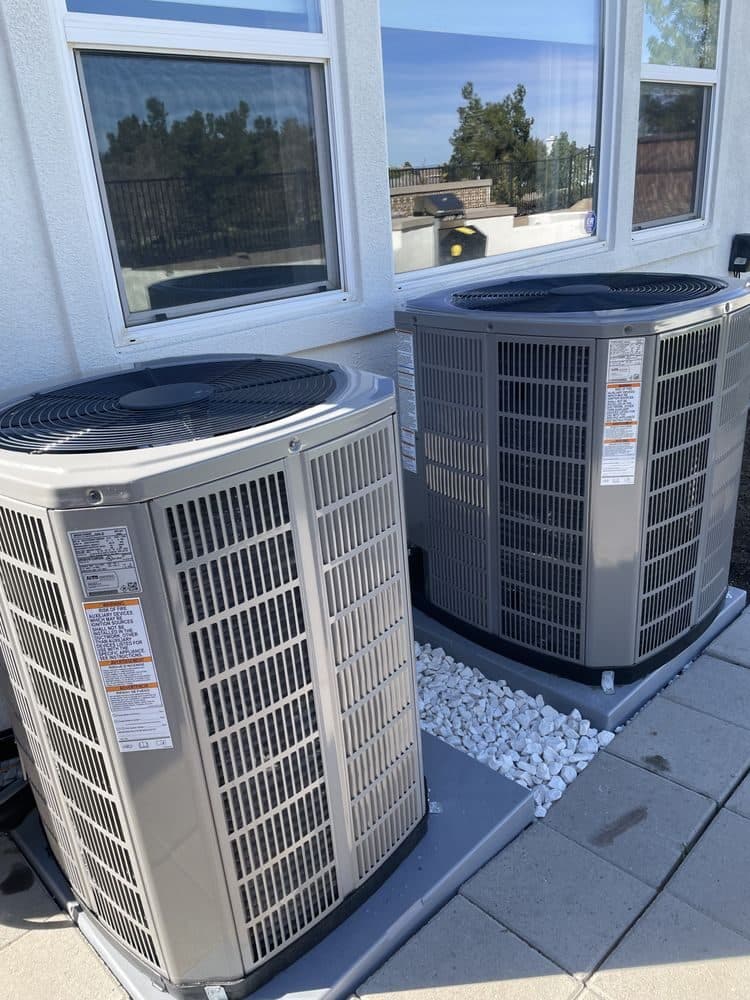 Two condensers installed side by side in a narrow side yard